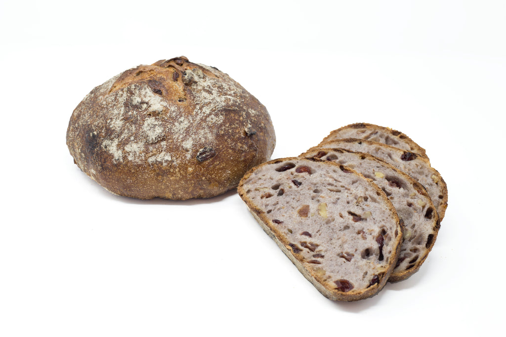 Photo of country sour cranberry walnut bread, whole and sliced