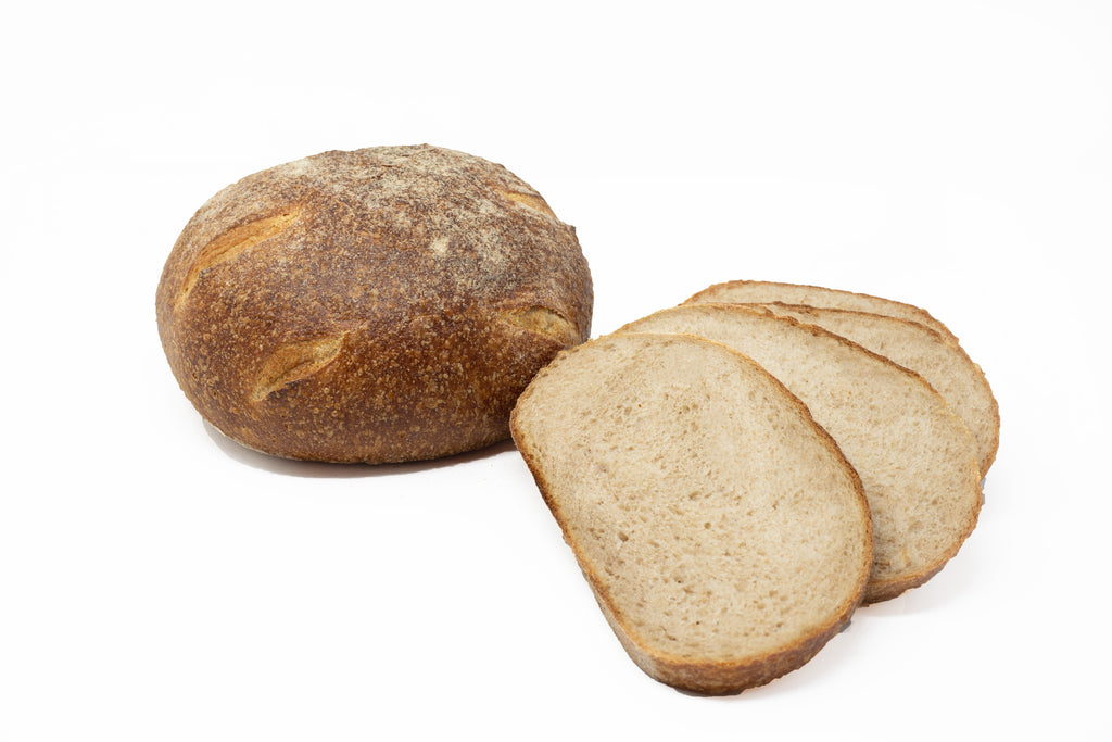 Photo of country sour whole wheat bread, whole and sliced